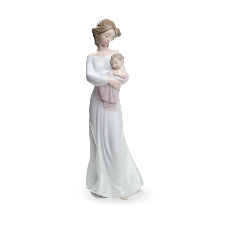 Porcelain figurine of a woman holding a baby, in a pale long dress