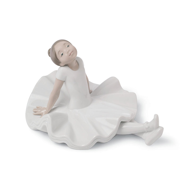 White porcelain ballerina figurine in a resting pose