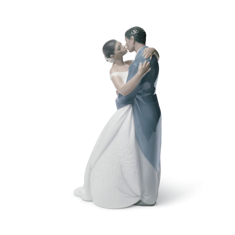 Porcelain figurine of a bride and groom in white and teal embracing, kiss pose