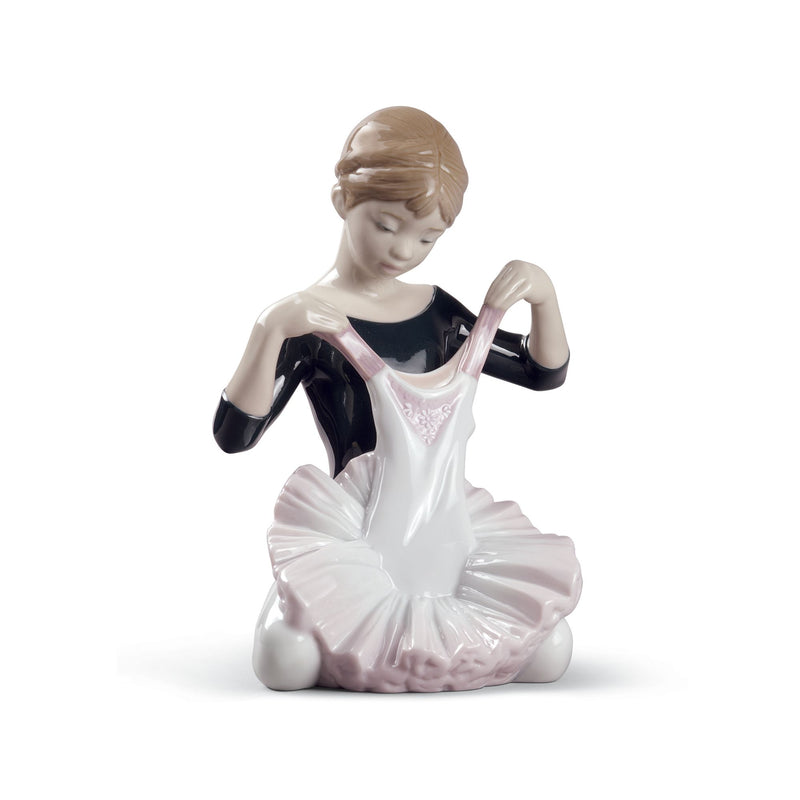 Porcelain figurine of a seated ballerina girl in white tutu with pink accents