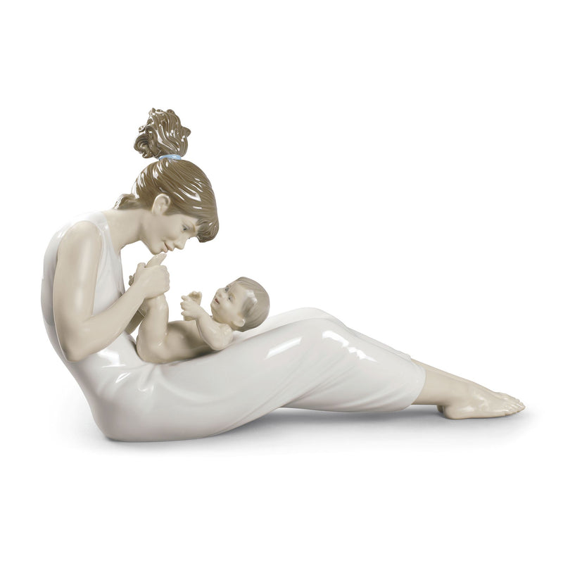 Lladro porcelain figurine of a mother holding a baby while reclining, smiling