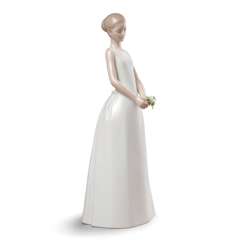 Porcelain bride figurine in white gown holding a small yellow bouquet, head bowed