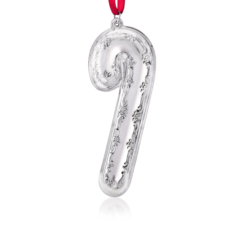 Sterling silver candy cane ornament with embossed scrollwork, hanging on red ribbon