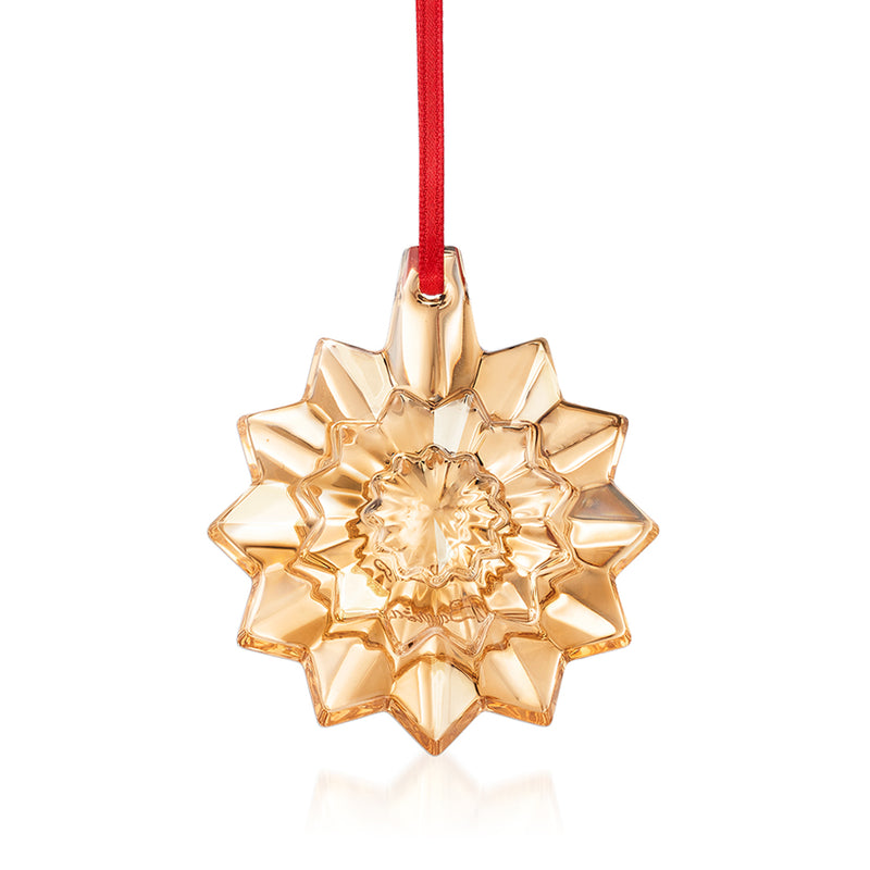 Baccarat crystal snowflake ornament in gold tone with hanging red ribbon