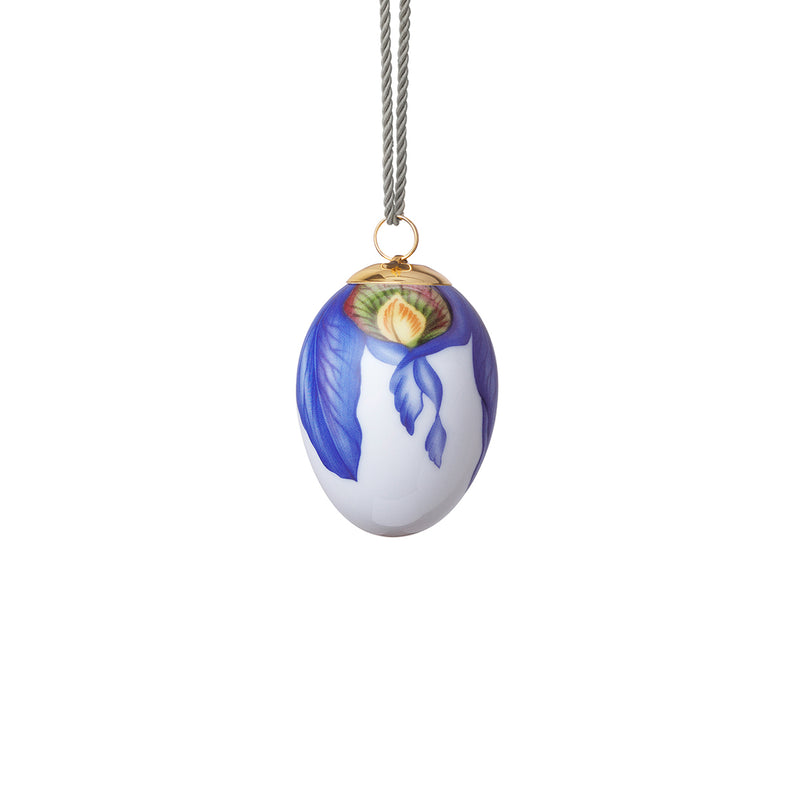Royal Copenhagen porcelain Easter egg ornament with blue iris petal design, hanging on cord.