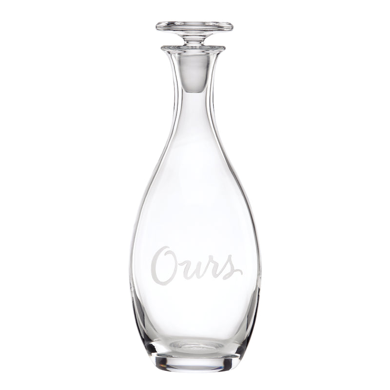 Clear glass decanter with 'Ours' etched on front and flared top neck
