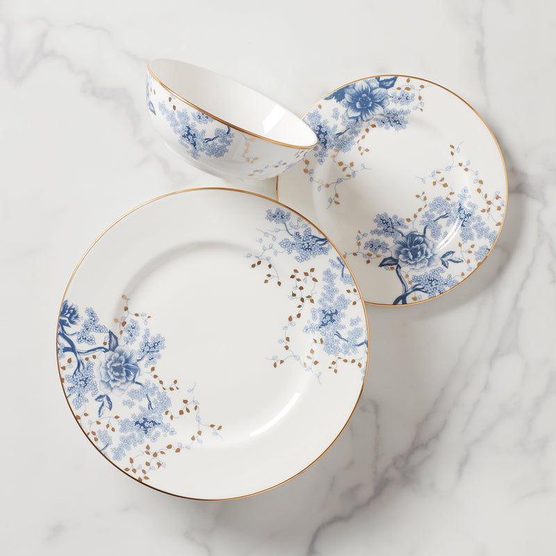 Porcelain place setting plates with blue floral design and gold trim