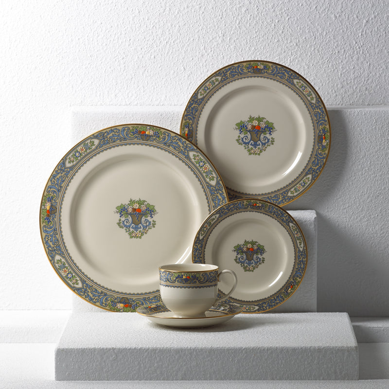 Porcelain place setting with two plates and a cup, blue-gold rim, floral center