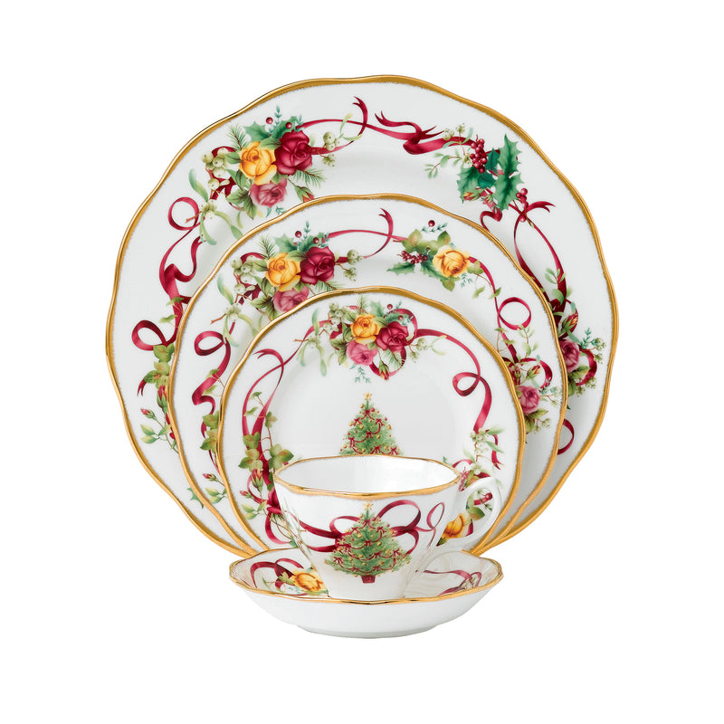 Porcelain 5-pc place setting with gold trim, roses, red ribbons, and small Christmas tree