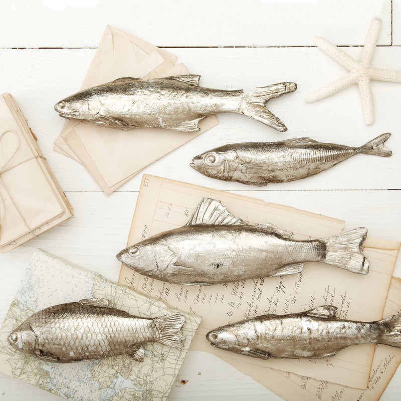 Set of five silver decorative fish ornaments with metallic scales and fins.