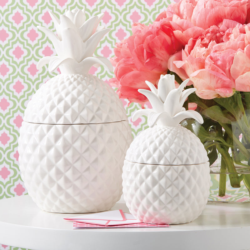 Set of two white ceramic pineapple-shaped storage jars with matching lids