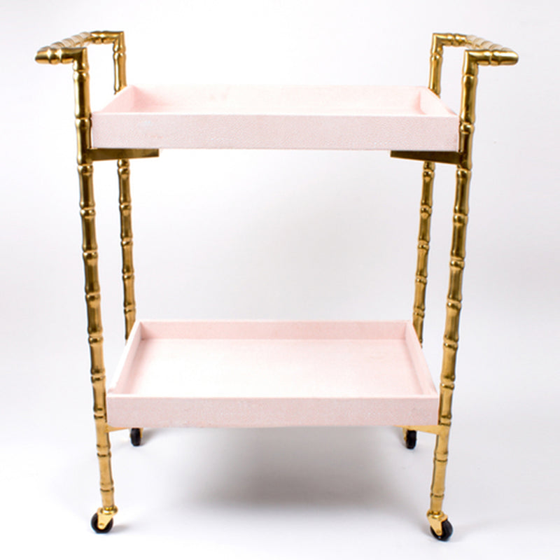 Blush pink and gold bamboo bar cart with two shelves and caster wheels