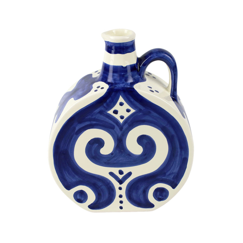 Cobalt blue and white round ceramic bottle with curved handle and ornate heart motif