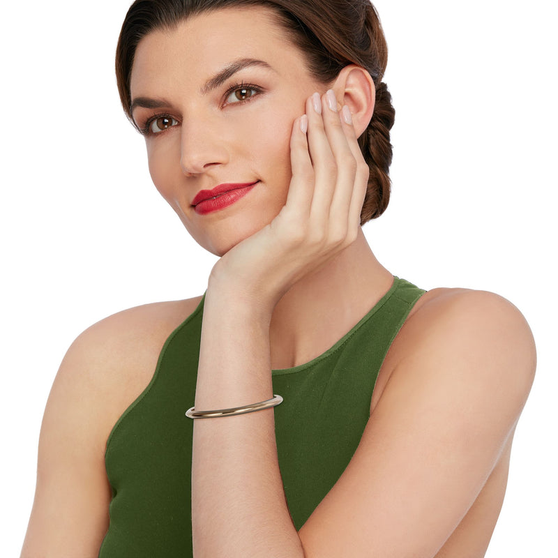 Roberto Coin oval bangle bracelet in 18kt yellow gold on model's wrist
