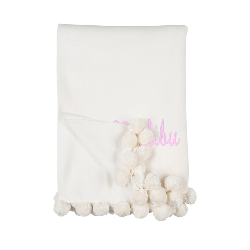 Ivory throw blanket with pink name embroidery and rounded pom pom fringe