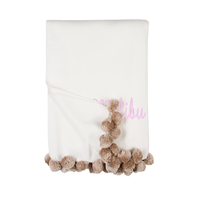 Ivory throw blanket with nude pom pom fringe and cursive name detail