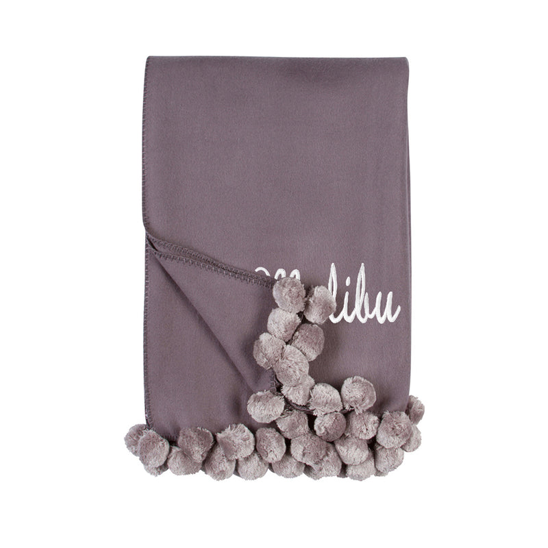 Dove grey pom pom throw blanket with cursive 'Lilu' and fluffy pom trim