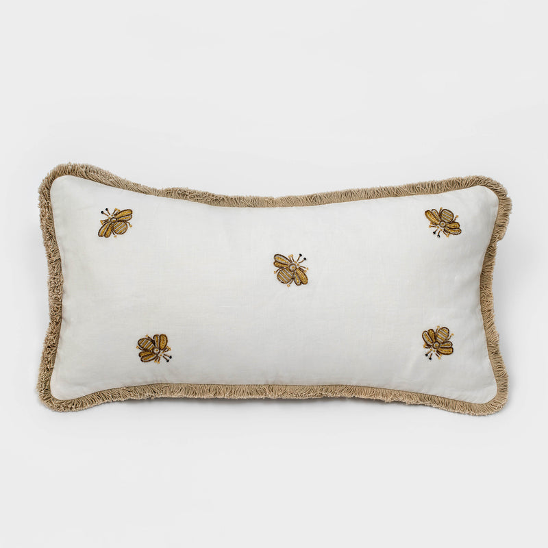 White linen lumbar pillow with embroidered bees and tan fringe trim