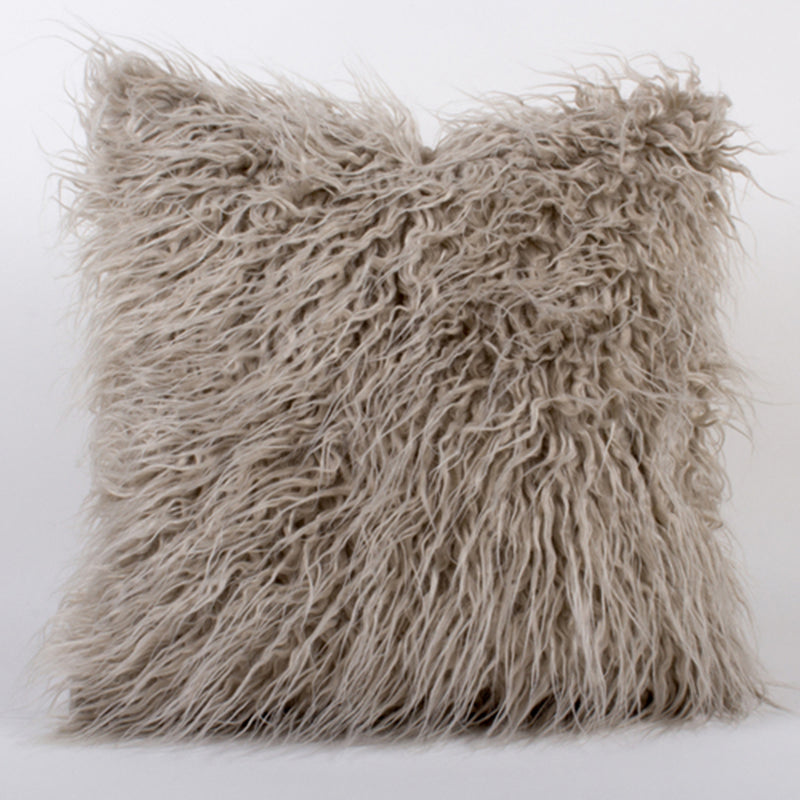 Gray Mongolian fur throw pillow with shaggy textured cover and fringed edges