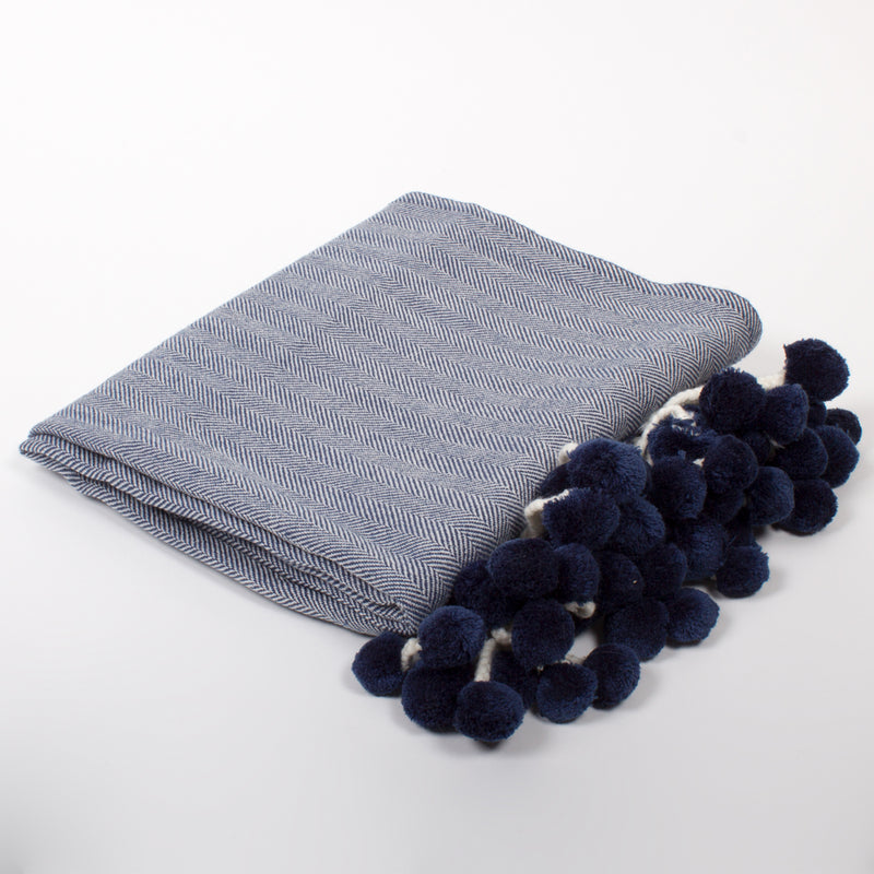 Herringbone throw blanket in blue with navy pom-pom fringe