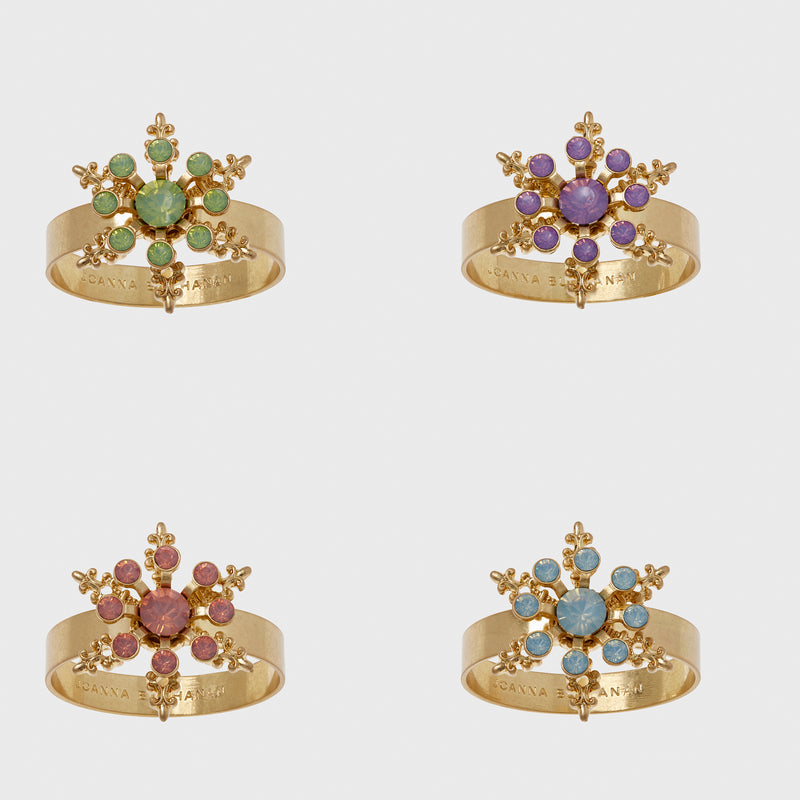 Set of 4 gold-tone snowflake napkin rings with jeweled centers in green, purple, red, blue