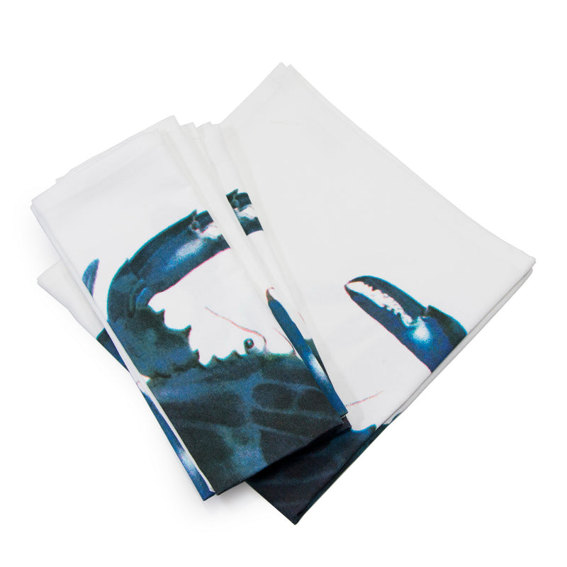 Set of 8 dinner napkins with blue crab print on white fabric, folded stack