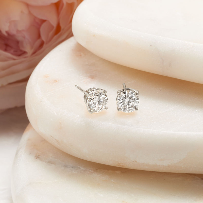 Round diamond stud earrings in white gold with six-prong settings and posts