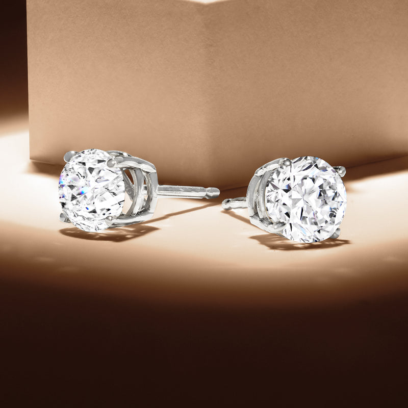 Round diamond stud earrings in white gold, side view of six-prong settings