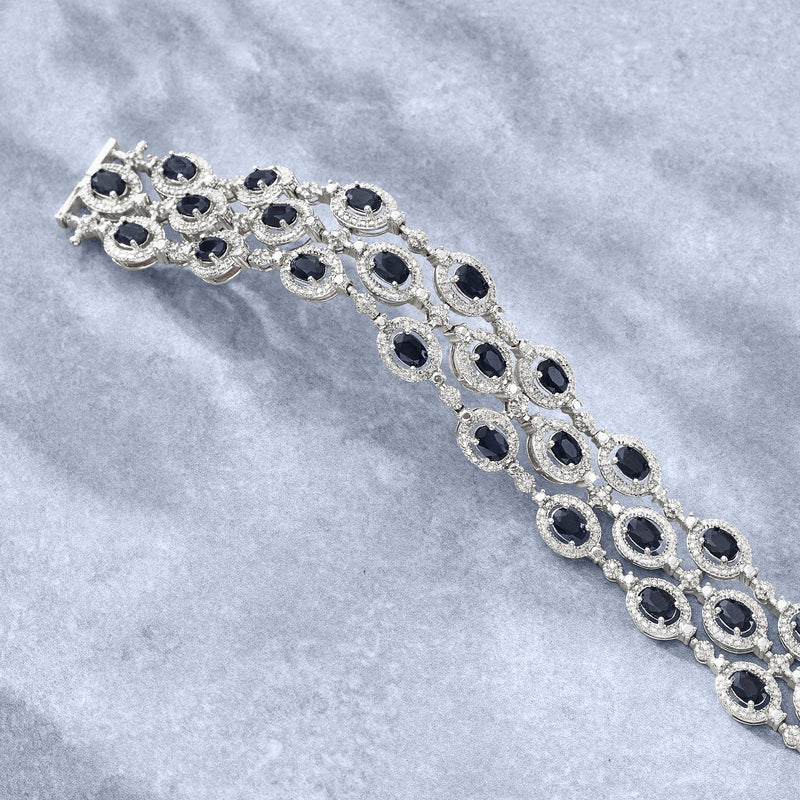 Sterling silver three-row bracelet with oval dark stones and diamond-like accents.