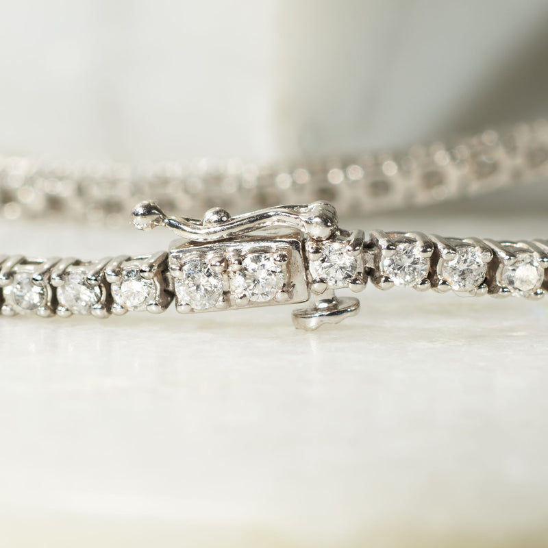Close-up of 14kt white gold diamond tennis bracelet clasp and linked settings