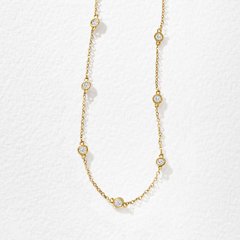 14kt yellow gold diamond station necklace with evenly spaced bezel-set round diamonds