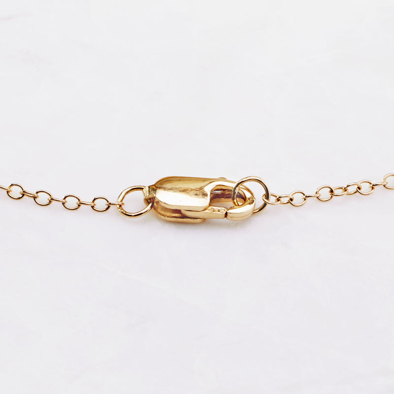 14kt yellow gold diamond station necklace close-up of bezel-set oval center link