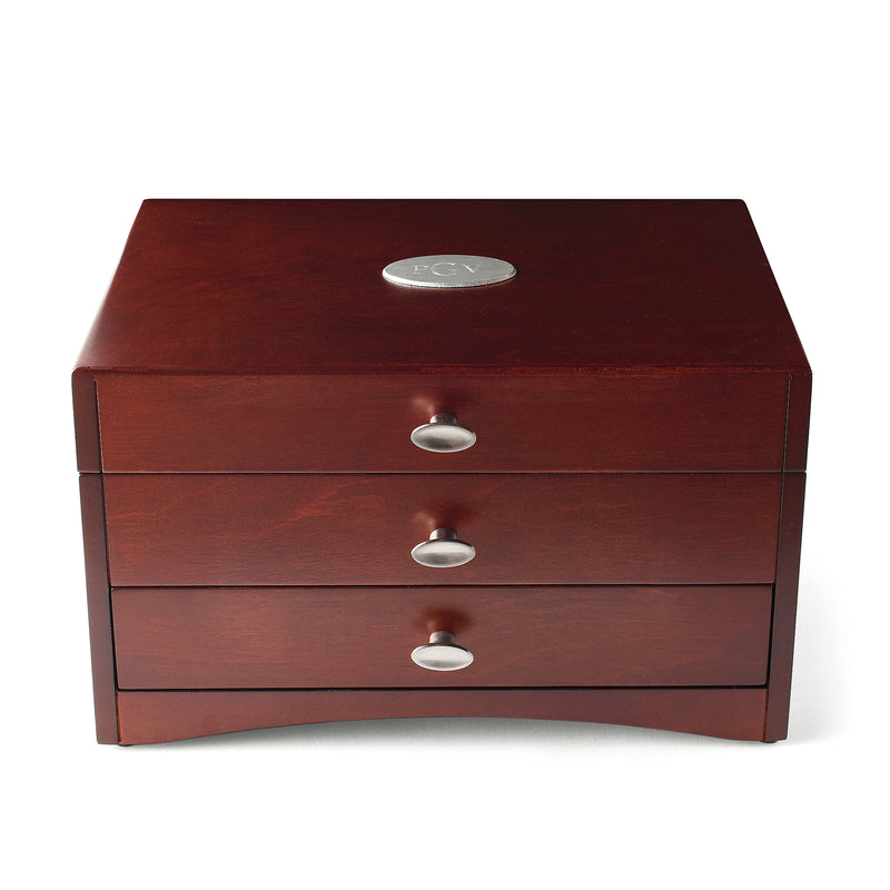 Dark wooden jewelry box with hinged lid, three drawers, silver knobs, and monogram medallion