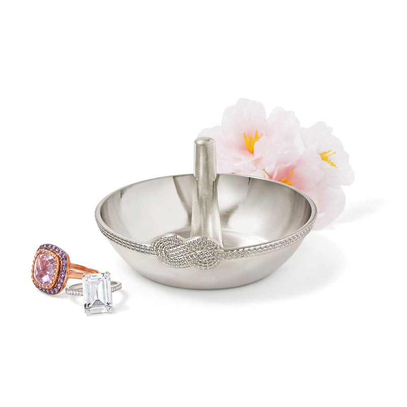 Silver metal infinity ring holder with shallow bowl, central post, and ring display.
