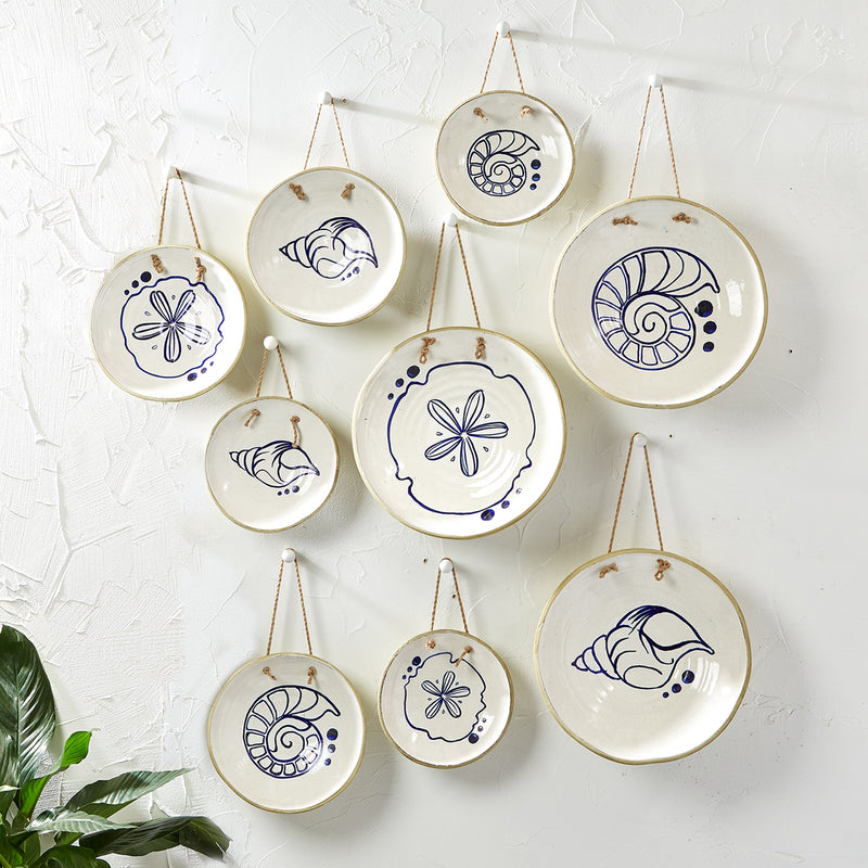 Set of nine hanging decorative ceramic plates with blue-and-white circular designs on cords