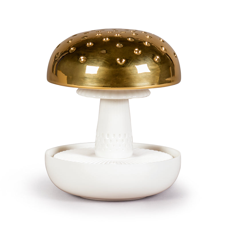Porcelain air diffuser with gold dome and white mushroom-shaped base.