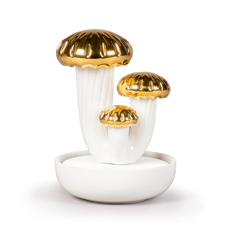 Porcelain air diffuser with three white mushroom stems and gold caps on a white base