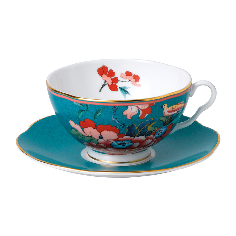 Floral teacup and saucer set with gold rim, bird and pink blooms on teal