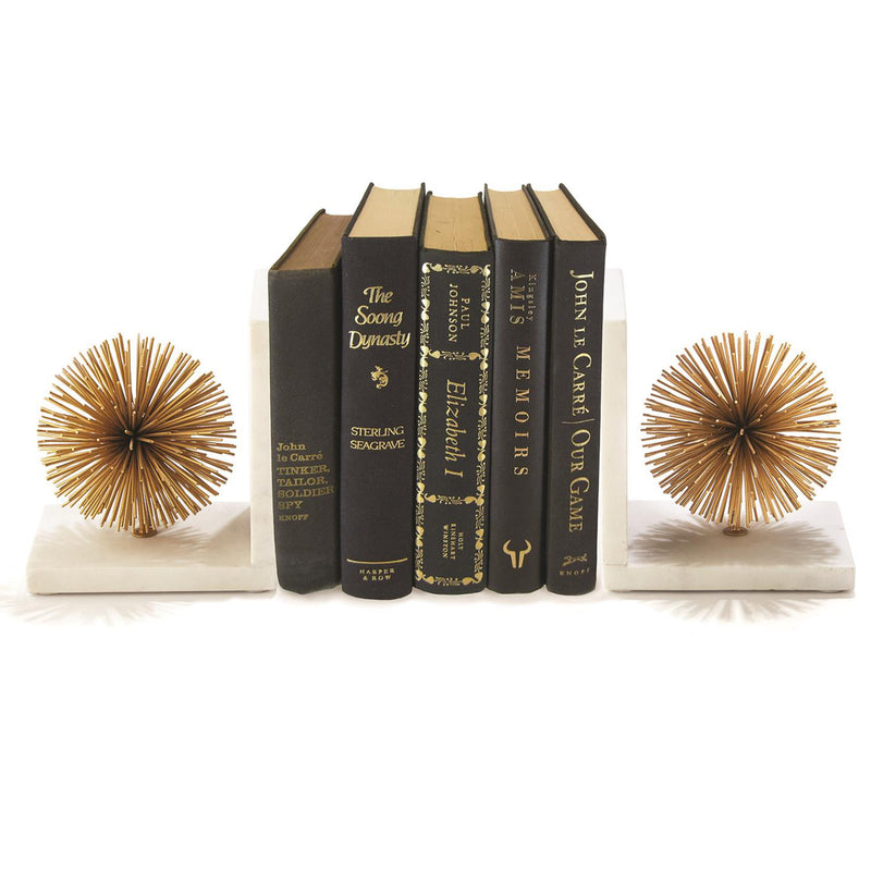 Set of 2 gold starburst bookends holding upright books