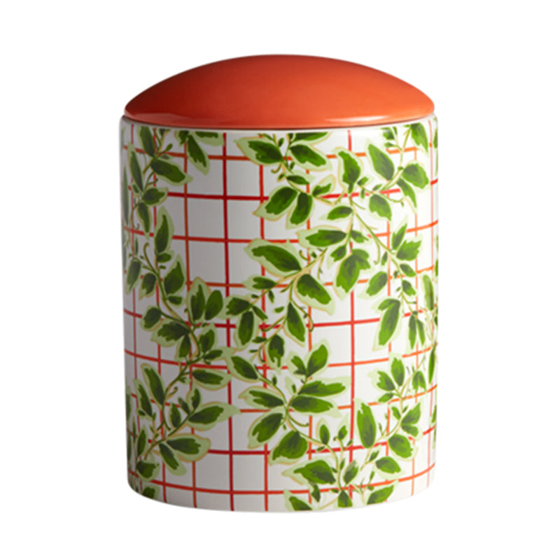 Large ceramic candle jar with green ivy leaves, red grid pattern, and orange lid