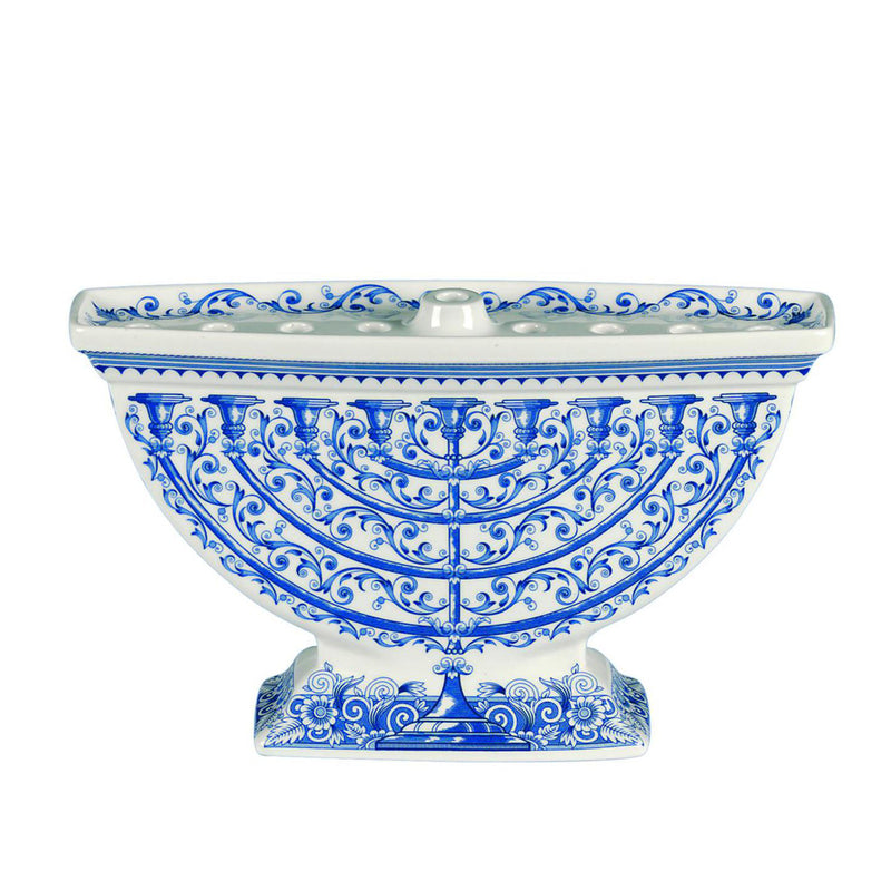Blue and white ceramic Judaica menorah with ornate scrollwork and pedestal base