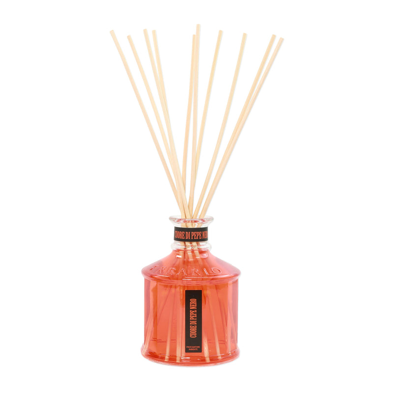 Orange glass reed diffuser with black label and light wood fragrance sticks