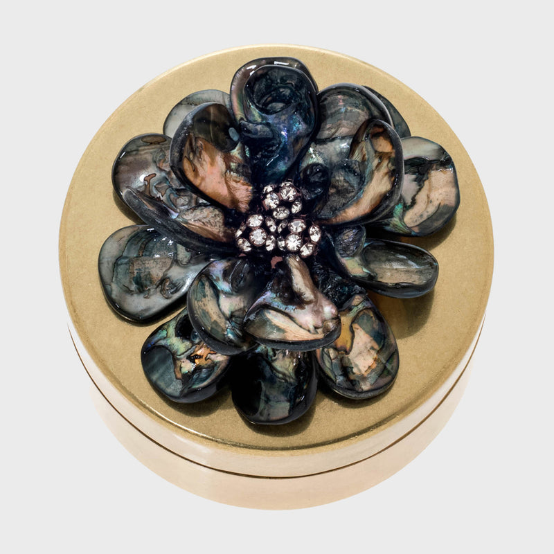 Round shell flower jewelry box with dark blue petals and jeweled center on beige lid
