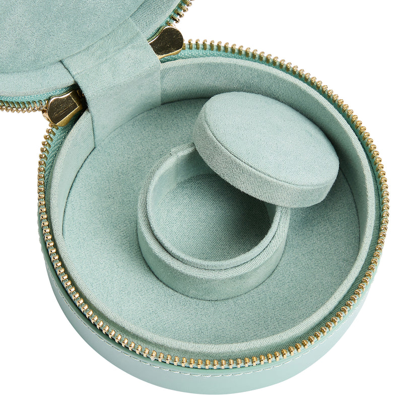 Open jade green jewelry zip case interior with gray ring cushion and gold-trim zipper edge.