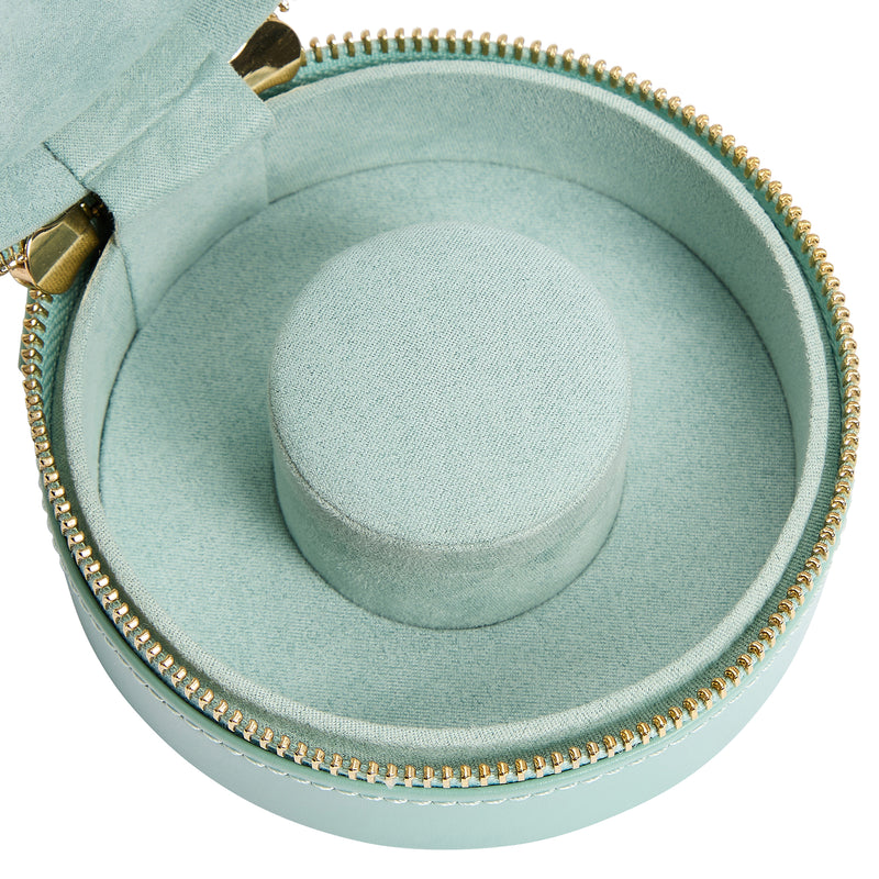 Close view of jade green jewelry zip case interior with gray circular ring cushion.