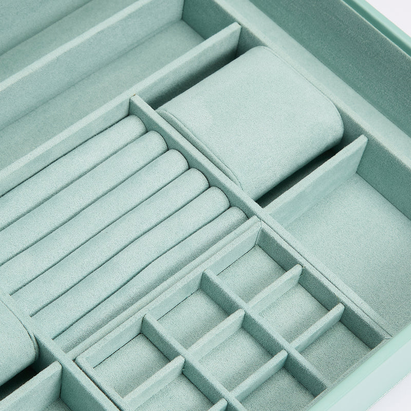Interior of jade green jewelry box with foam pads and segmented ring holders