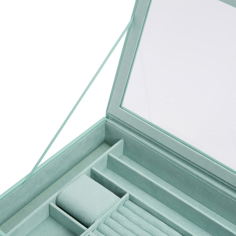 Close-up of jade green jewelry box compartments with cushioned ring holder sections