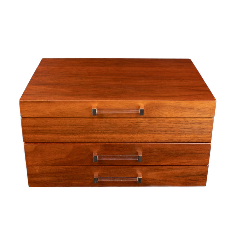 Walnut wood jewelry box with three drawers and metal pull handles, lid closed