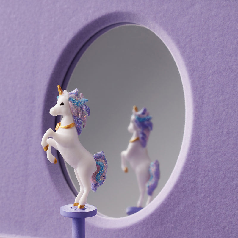 Unicorn figurines inside an oval window on a musical jewelry box