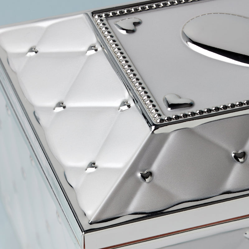 Heart-inlay lid detail on a musical jewelry box with jeweled trim border